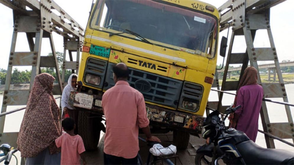 সেতুর পাটাতন ভেঙে আটকে গেল ট্রাক