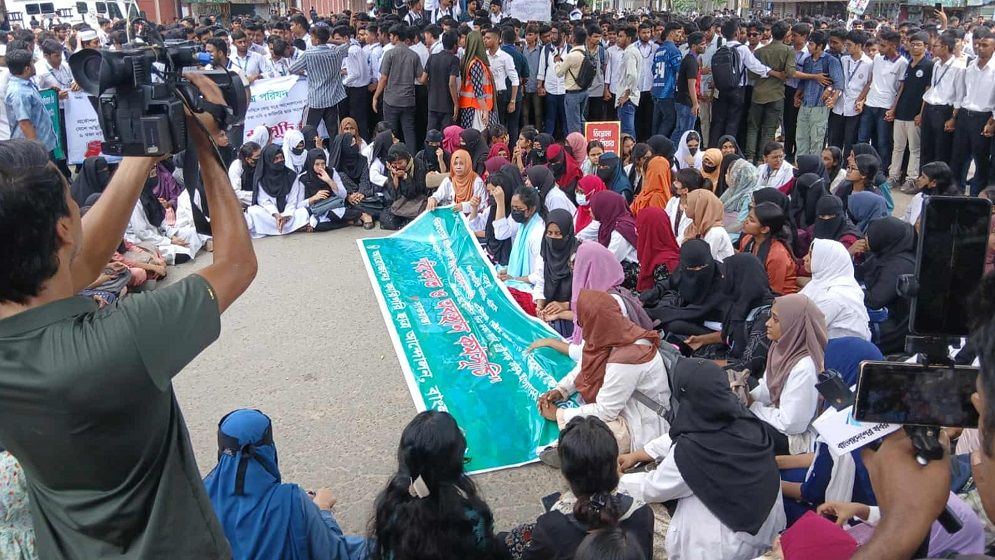 সাতরাস্তা মোড়ে যান চলাচলের পথ ছেড়ে দিয়ে কর্মসূচি পালন করছেন শিক্ষার্থীরা